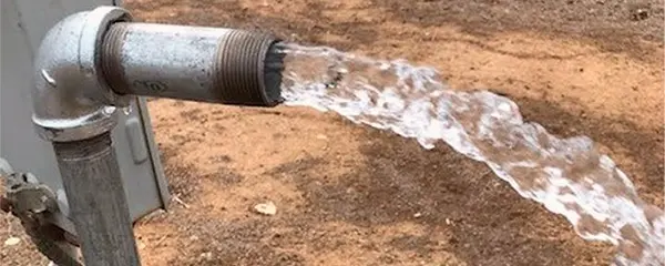 Agua saliendo de un pozo recién perforado